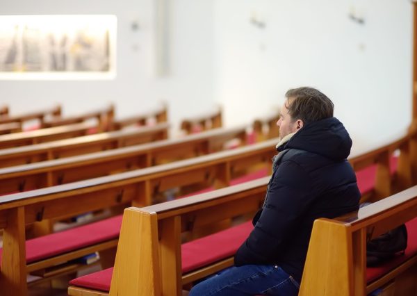 religious-middle-age-man-praying-in-catholic-churc-2022-11-11-19-17-31-utc